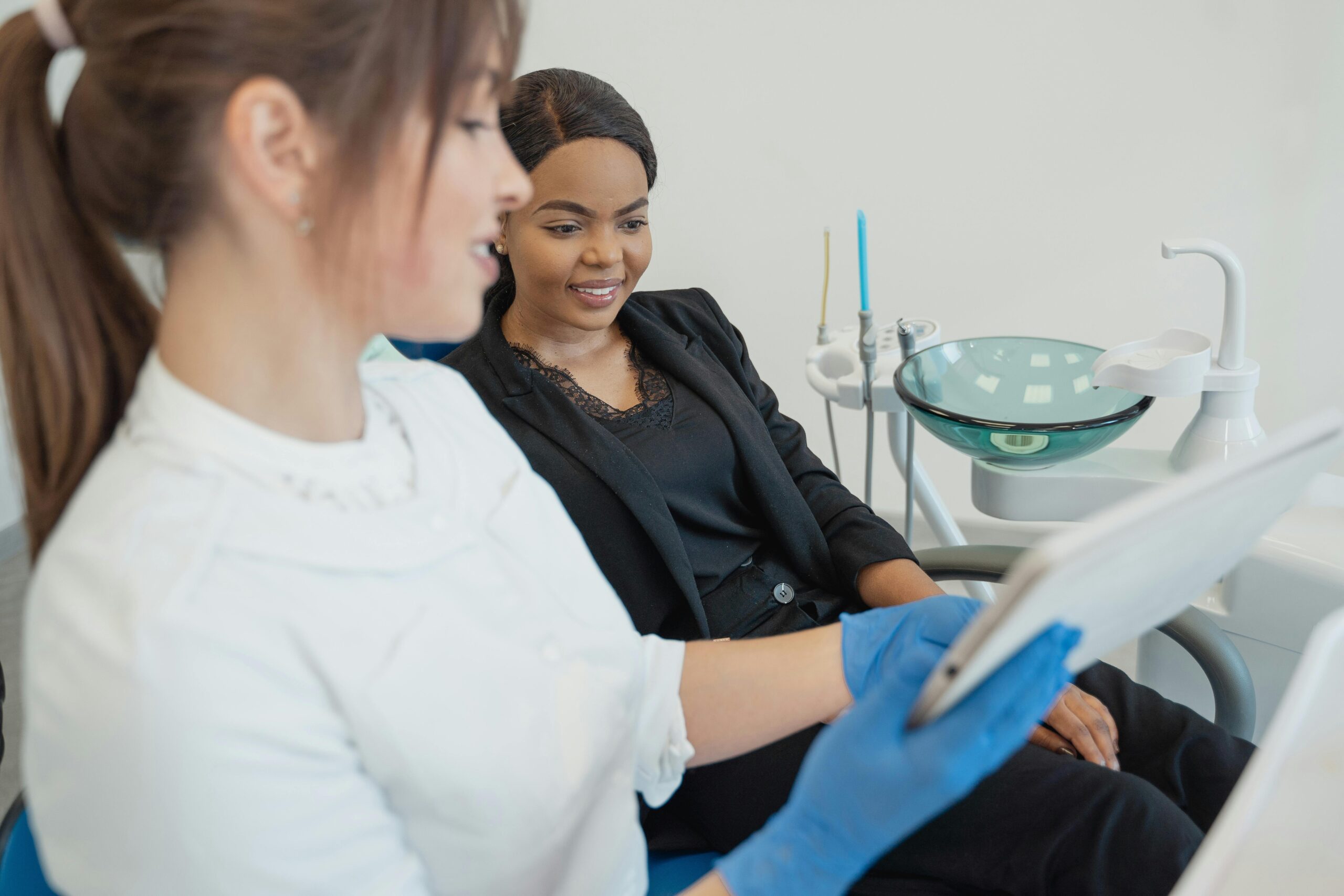 How Patients Benefit from FHIR-Enabled Providers Healthcare professional discussing dental treatment with patient using a tablet device in a modern clinic setting.