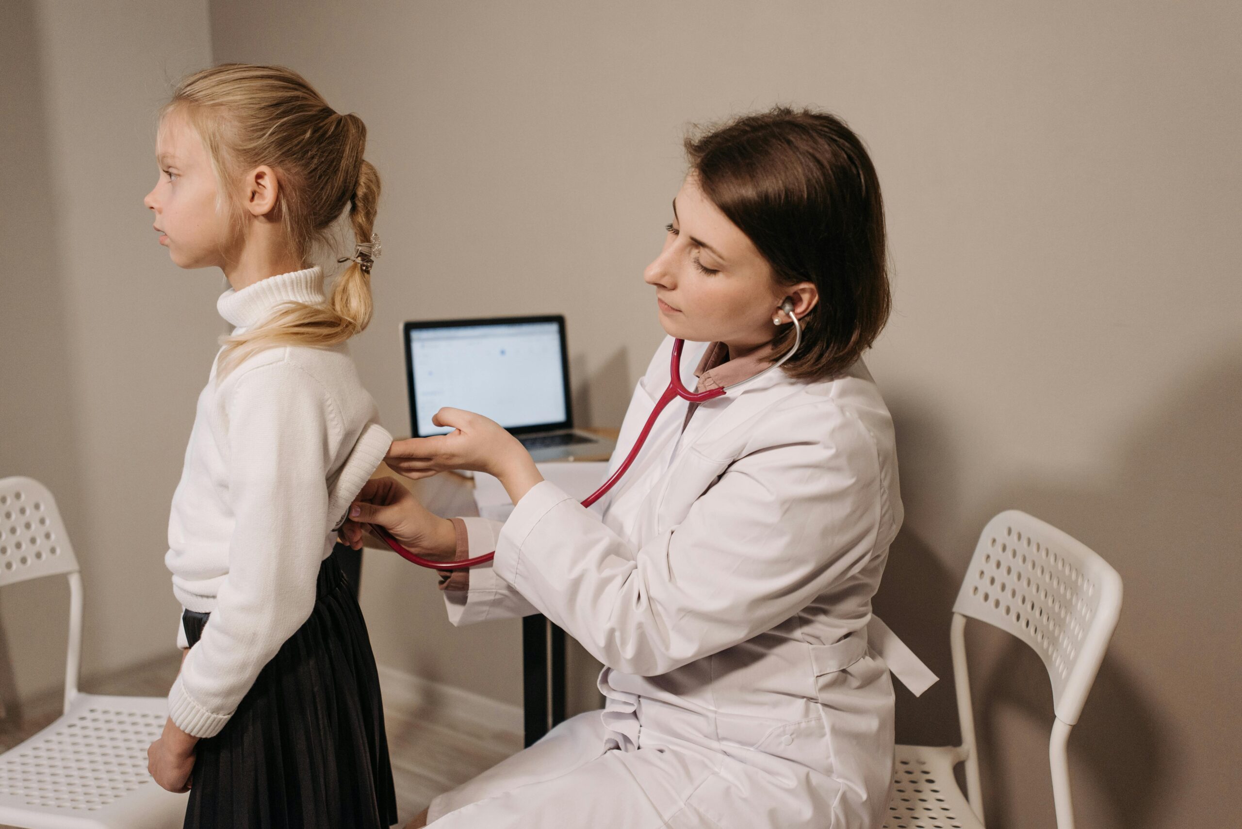 Direct Primary Care Broke Up with Insurance — But You Still Need Interoperability A doctor uses a stethoscope during a child's medical exam in a clinic setting.